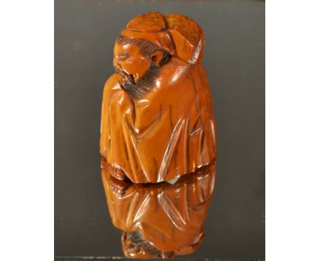 A Japanese netsuke of a crouching elder