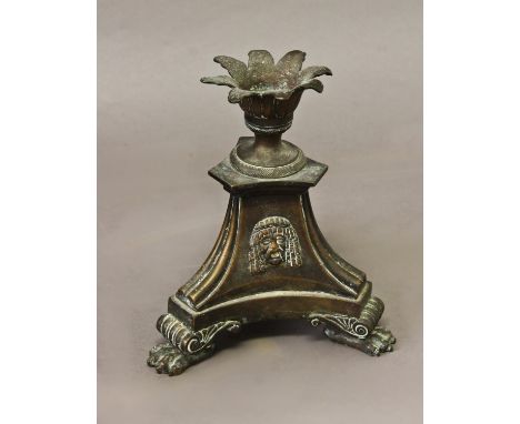A 19TH CENTURY BRONZE CANDLESTICK IN THE MANNER OF THOMAS HOPE, with a splayed leaf form sconce on a tri-form base with Egypt