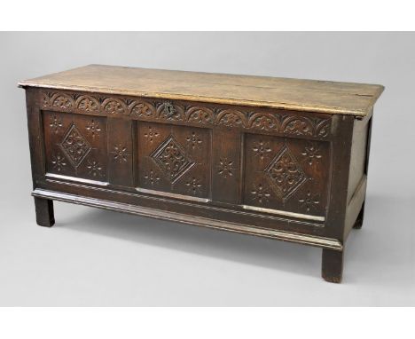 A 17TH CENTURY OAK COFFER, with a two plank top above a three panel front with carved lozenge decoration and a frieze of runn