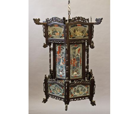 A CHINESE HARDWOOD FRAMED HANGING LANTERN, of hexagonal form with carved and pierced structural elements housing eighteen gla
