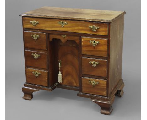 A GEORGE II/III MAHOGANY KNEEHOLE WRITING DESK, with a rectangular top with moulded border above an arrangement of seven draw