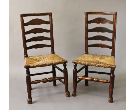 A PAIR OF LATE 18TH CENTURY RUSH SEATED LADDER BACK ARM CHAIRS, each with a dished top rail above four graduated ladders abov