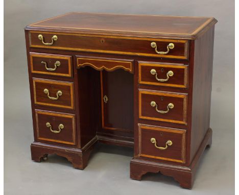 A GEORGE III STYLE MAHOGANY KNEEHOLE WRITING DESK, the rectangular top with moulded border and rounded corners with broad sat