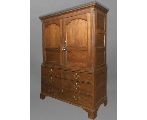 A GEORGE III OAK LIVERY CUPBOARD, the upper section with a moulded cornice above twin doors with arch topped panels flanked b