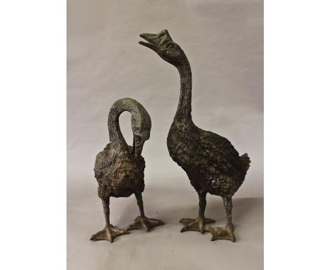 TWO BRONZE EFFECT SCULPTURAL GARDEN GEESE ORNAMENTS, one with head raised, the other lowered, 39 and 54cm high (2)