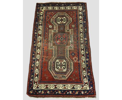 KAZAK RUG,  Central Caucasus, circa 1880. The madder field with double 'key hole' panel containing octagons surrounded by tri