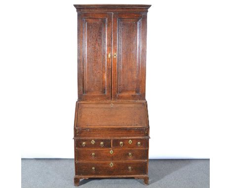 An oak bureau bookcase, 18th century, moulded cornice, two fielded panelled doors enclosing shelves, fall front with a steppe