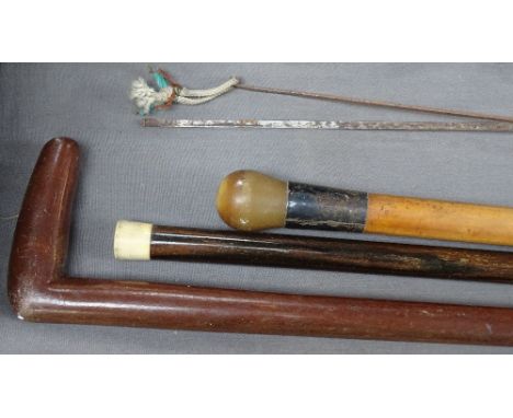 An ivory-tipped walking cane, a horn and silver-handled Malacca cane, and a long hardwood stick (3) 