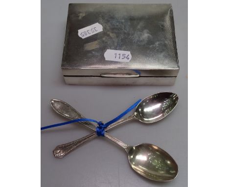 An engine turned rectangular silver cigarette box, and 2 silver teaspoons 