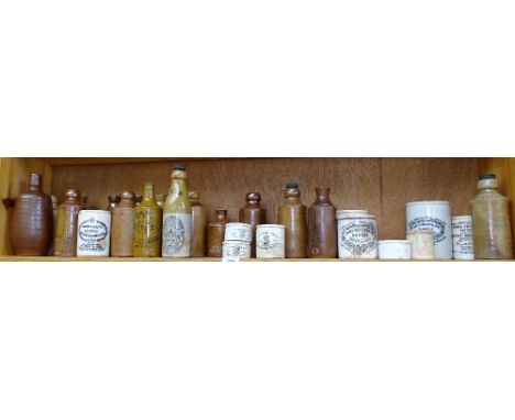 A shelf of ginger beer bottles, printed stoneware jars etc 