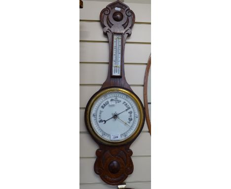 A carved oak-framed aneroid barometer with thermometer, 32" 