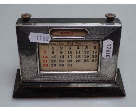 An Edwardian engine turned silver-fronted desk calendar 