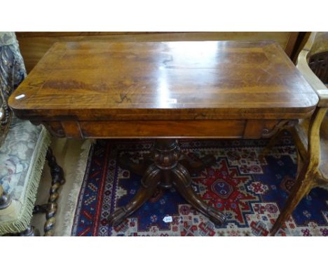 A 19th century cross-banded mahogany fold over card table, on turned centre column and sabre leg base, W92cm 