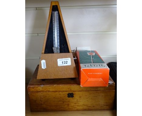 A metronome, a box with printer's letters, and a Taktell metronome 