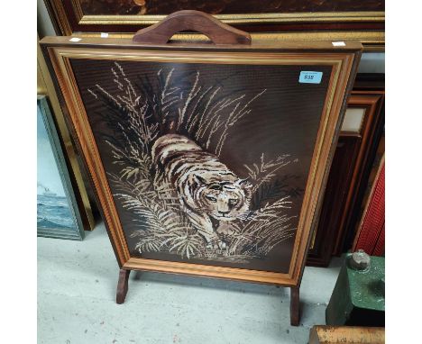 An oak framed tapestry fire screen depicting a prowling tiger and a reproduction occasional magazine rack