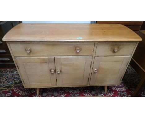 A 1960's Ercol light elm sideboard of 2 drawers and 3 cupboards, model 1351 with blue label