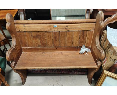 A pitch pine two seater panelled bench, 109cm
