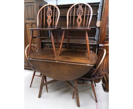 An Ercol elm dining suite comprising oval drop leaf table, 4 wheel back chars + a dresser with three height shelf, 3 drawers 