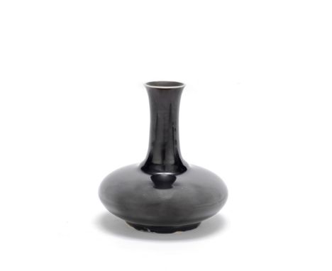 A MIRROR BLACK-GLAZED BOTTLE VASEKangxiThe compressed globular body rising to a tall gently flaring cylindrical neck, covered