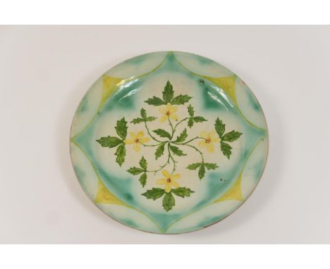 Della Robbia plate, by Emily Wood, circa 1900, decorated with a symmetrical spray of primroses in greens and yellows against 