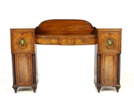 Regency mahogany twin pedestal sideboard, circa 1815-25, having a central bow front fitted with three frieze drawers, support