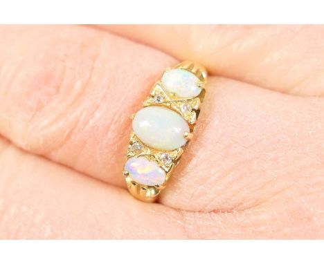 Opal and diamond cluster ring, the central cabochon opal approx. 6mm x 4mm bordered with tiny brilliants and the shoulders fu