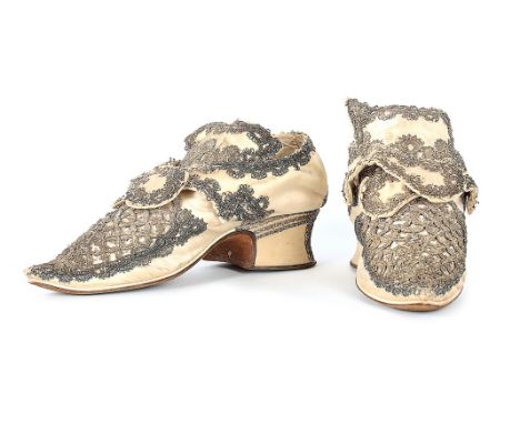 A fine pair of silver lace and ivory satin ladies shoes, circa 1720-30, with pointed toes which over-hang the white leather r