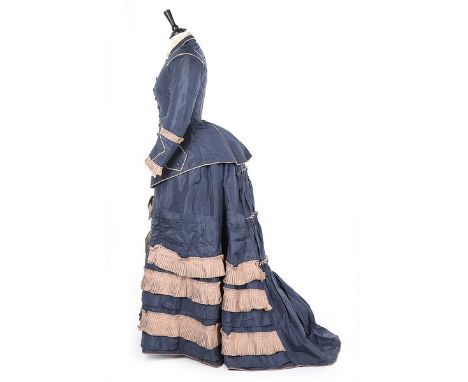 A bi-colour silk faille gown, late 1870s, the long jacket-like bodice with ecru wool piping and pleated trims, with fob pocke