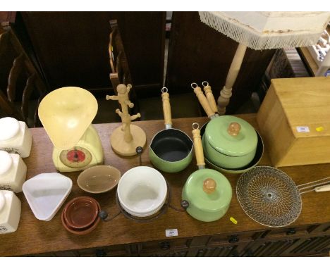 A wooden bread bin; a set of green metal saucepans and matching frying pan; a set of Salter scales; three storage jars etc.