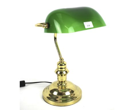 A contemporary desk lamp. The brass frame with a green glass shade, on circular base, H40cm