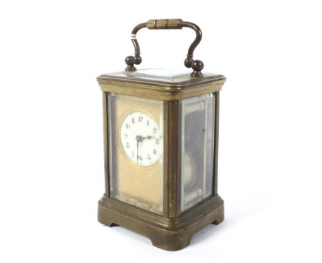 A minature brass carriage clock. The white dial with Arabic numerals, and a swing carrying handle, H7cm