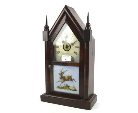 An early 20th century North American mantle clock by Waterbury clock company. Wooden dial with Roman numerals, the the opaque