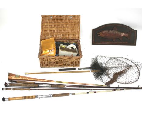 An assortment of fishing related items. Including rods, nets, a mounted taxidermy fish, wicker hamper, etc