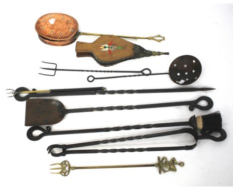 A collection of wrought iron fire tools, a bellows, a brass fork and other metalware.