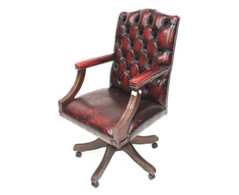 A faux leather button back and stud work captains swivel chair. Raised on a quatrefoil base to casters, H103cm.