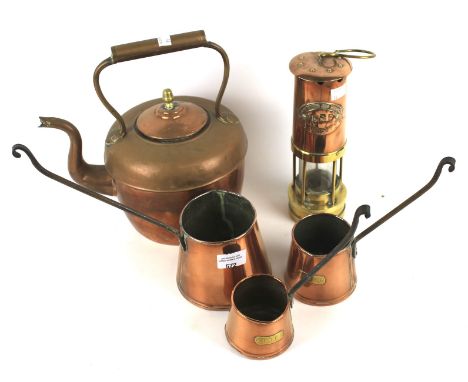 An assortment of copper to include a copper kettle,measuring jugs and a miners lamp