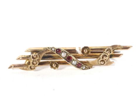 A 9ct rose metal, ruby and pearl brooch. Marked '9ct' (rubbed), with engraved, pierced and floral details, weight 1.9g