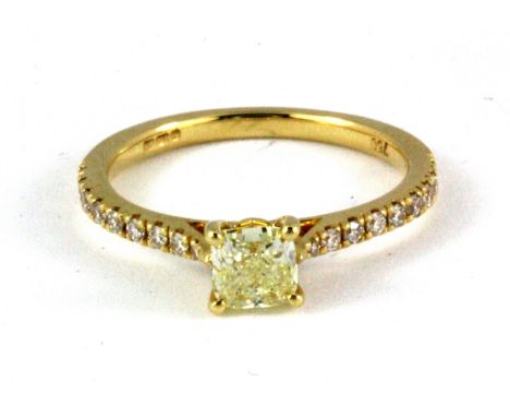 An 18ct yellow gold solitaire ring set with a 0.61ct cushion modified brilliant cut natural fancy yellow diamond with diamond