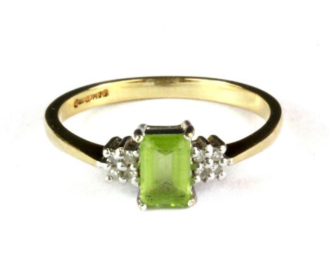 A 9ct yellow gold ring set with a baguette cut peridot and diamond set shoulders, (P.5).