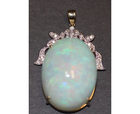 A 14ct yellow gold (stamped 585) pendant set with a large 42.59ct cabochon cut opal and brilliant cut diamonds, L. 4cm. Opal 