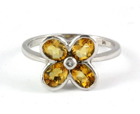 A 9ct white gold flower shaped ring set with oval cut citrines and a diamond, (O).