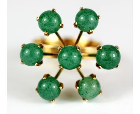 A 14ct yellow gold (stamped 585) ring set with five polished nephrite jade, Dia. 2.5cm, (L).