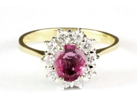 An 18ct yellow gold ruby and diamond set cluster ring, (O.5).