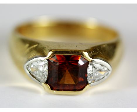 A gentleman's 14ct yellow gold (stamped 14k) ring set with a square step cut spessartine garnet and trillion cut diamonds, (K