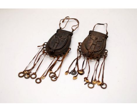 2 AFRICAN MEDICINE MAN BRONZE SPOREN TYPE POCKETS WITH LEATHER TASSELS AND SHELLS