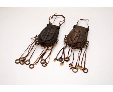 2 AFRICAN MEDICINE MAN BRONZE SPOREN TYPE POCKETS WITH LEATHER TASSELS AND SHELLS