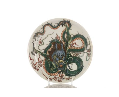 A Chinese Famille Verte dragon dish, painted with a facing dragon before its writhing body amongst flaming clouds, the unders