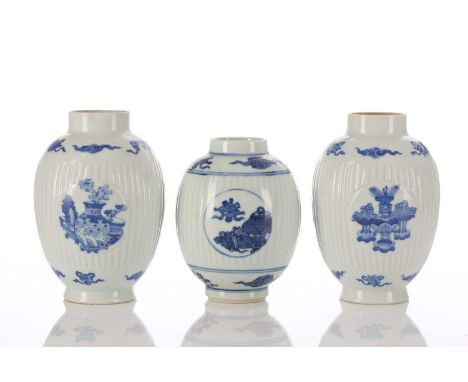 A near pair of Chinese blue &amp; white caddies, of barrel form, the rib moulded bodies with medallions painted with antiques