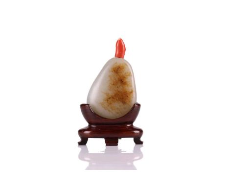 A Chinese jade pebble shape snuff bottle, 20th century, of pear form with a coral stopper, the stone with russet inclusions, 
