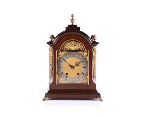 An early 20th-century German 8-day mantle clock with mahogany broken arch case with angel spandrels and silver chapter ring, 